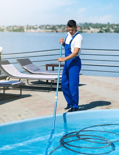 employee cleaning pool water
